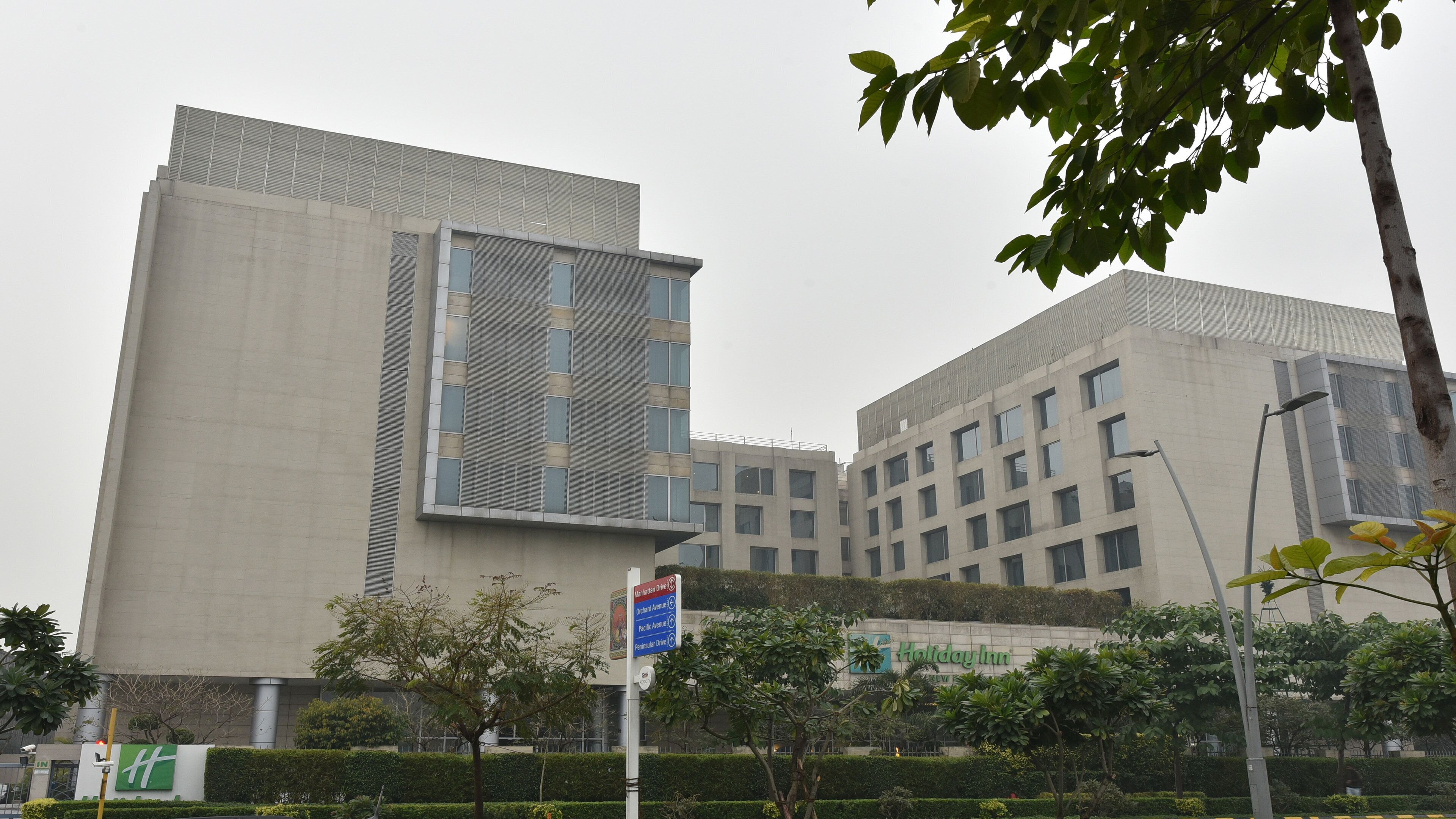A modern building with a large glass facade and a sign for Holiday Inn.