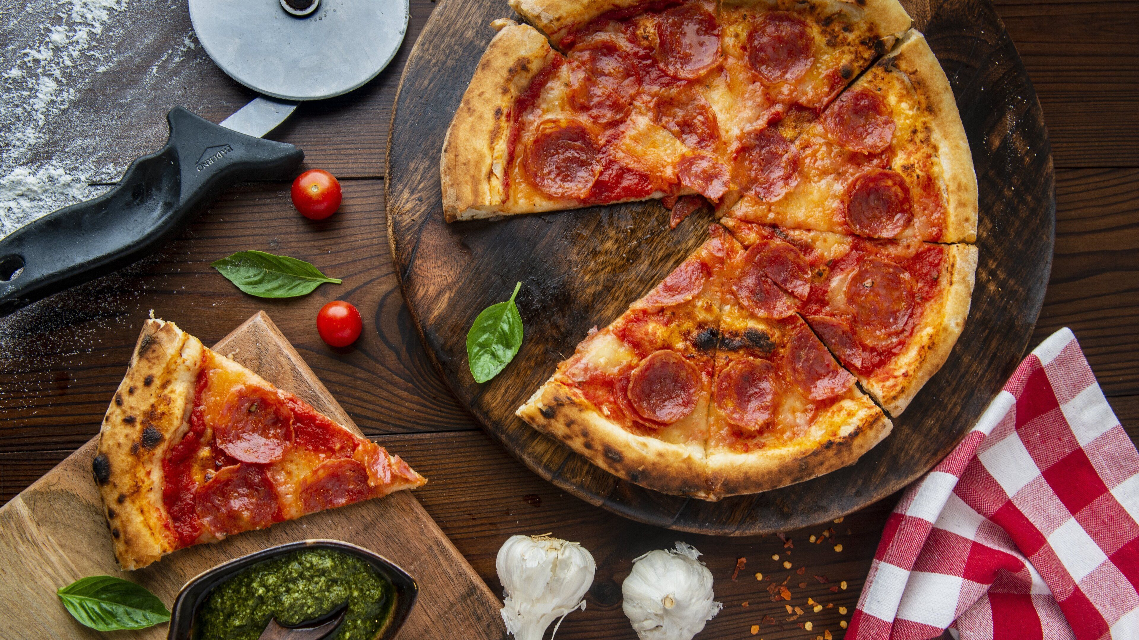 A pizza with pepperoni slices on a wooden board.