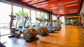 A gym with treadmills, elliptical machines, and exercise equipment.