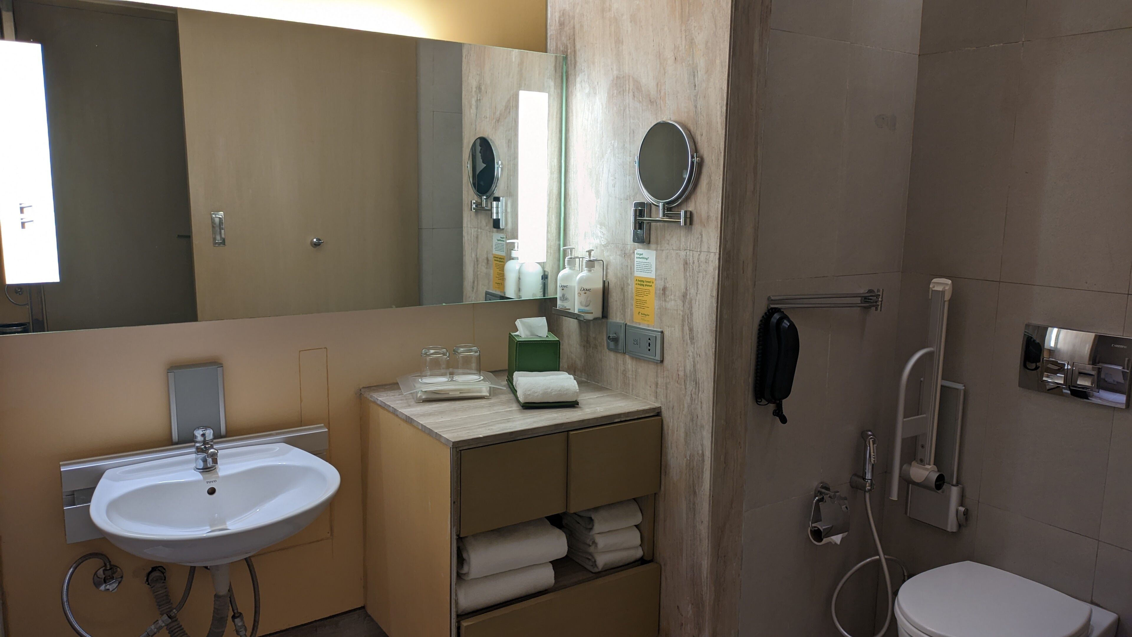 A modern bathroom with a sink, mirror, towel rack, and shower.