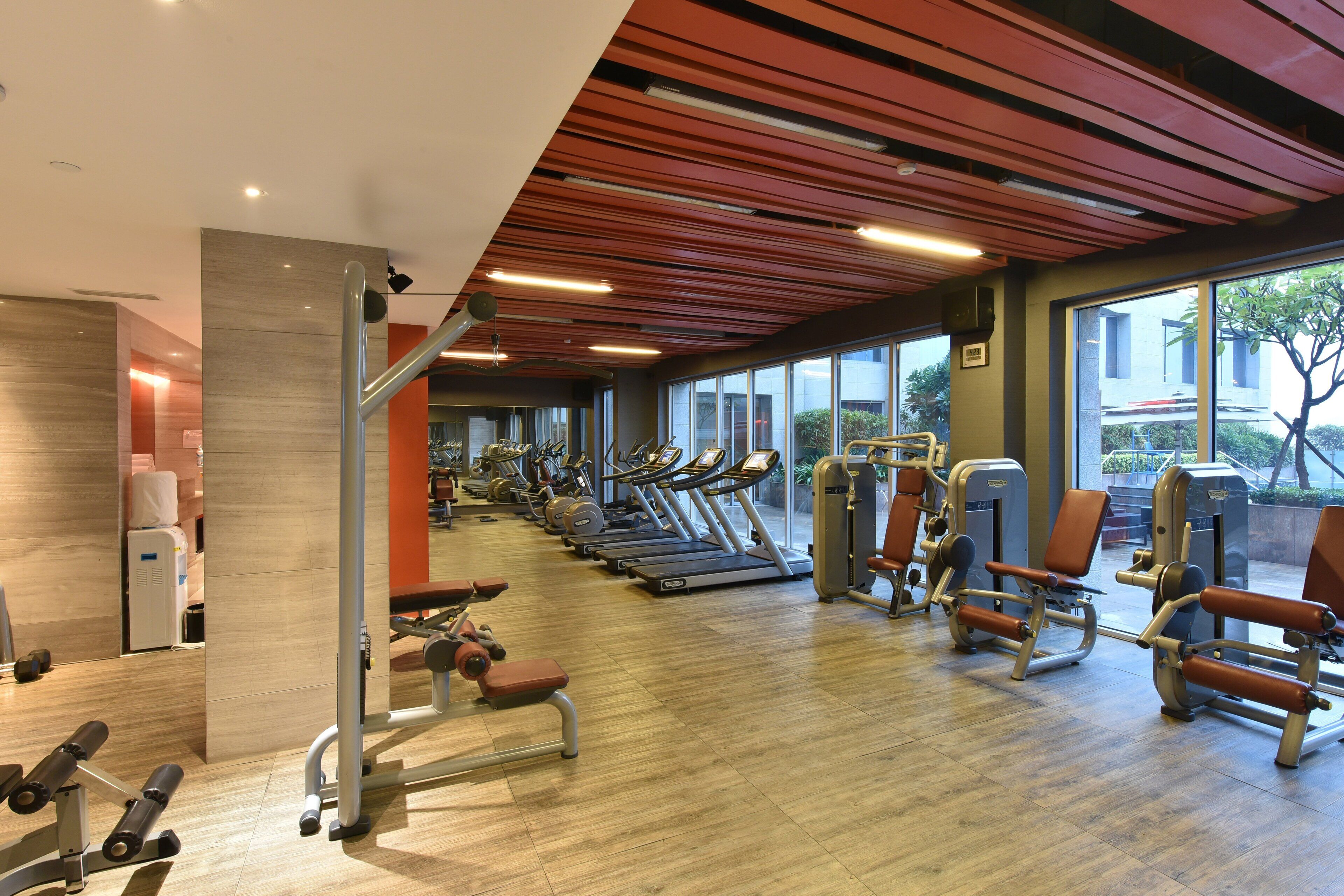 Et fitnesscenter med løbebånd, træningsmaskiner og træningsudstyr.