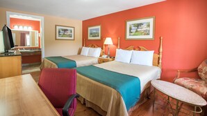A hotel room with two beds, a desk, a chair, and a small table. - The Hillside Hotel (Knoxville)