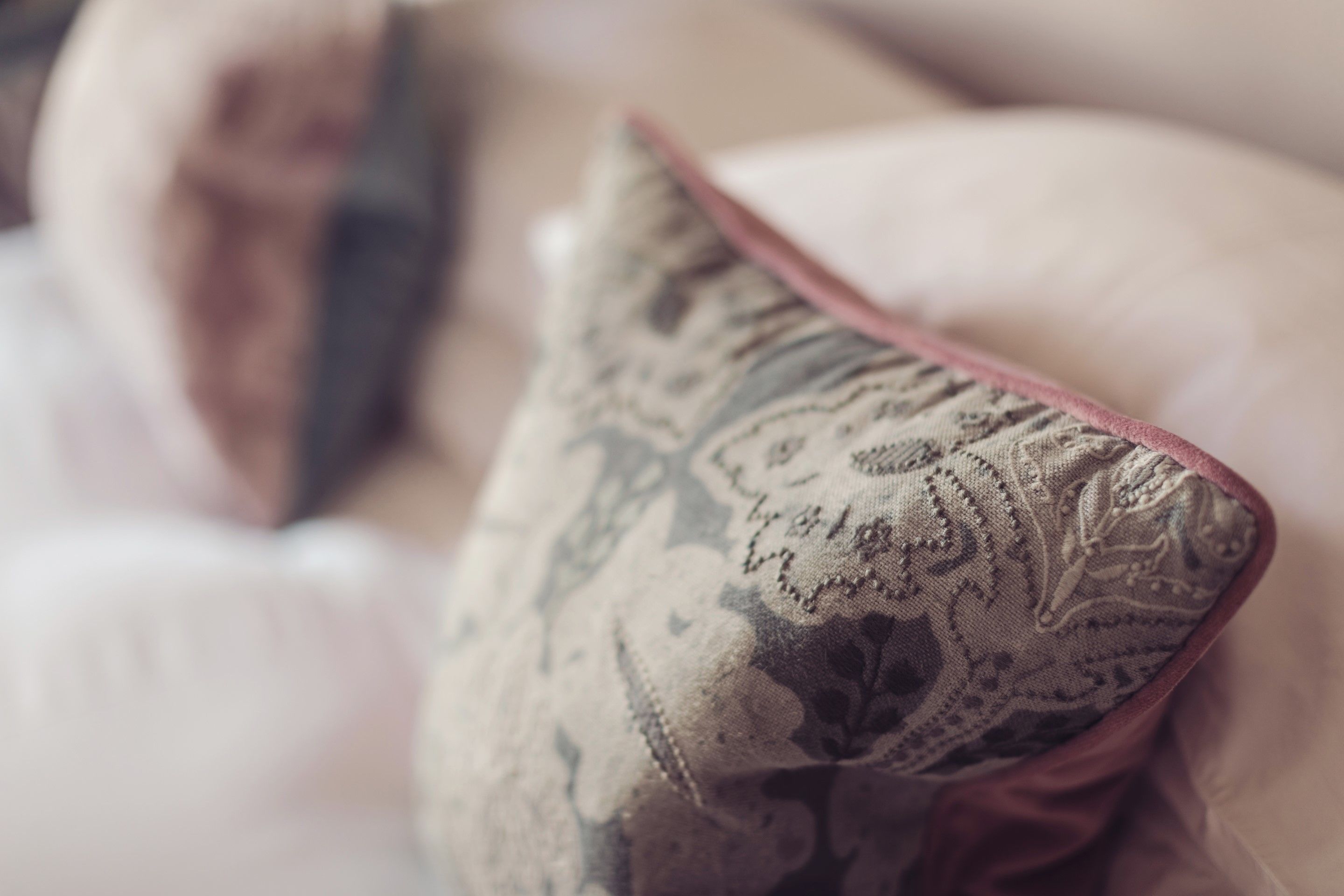 A close-up of a pillow with a paisley pattern on a bed.