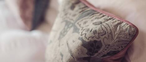 A close-up of a pillow with a paisley pattern on a bed.