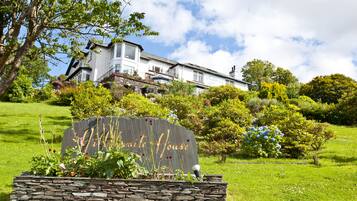 A sign for "Hawite House" with a stone wall and garden in front.