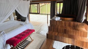 Un dormitorio con cama, espacio para sentarse y vistas al exterior.