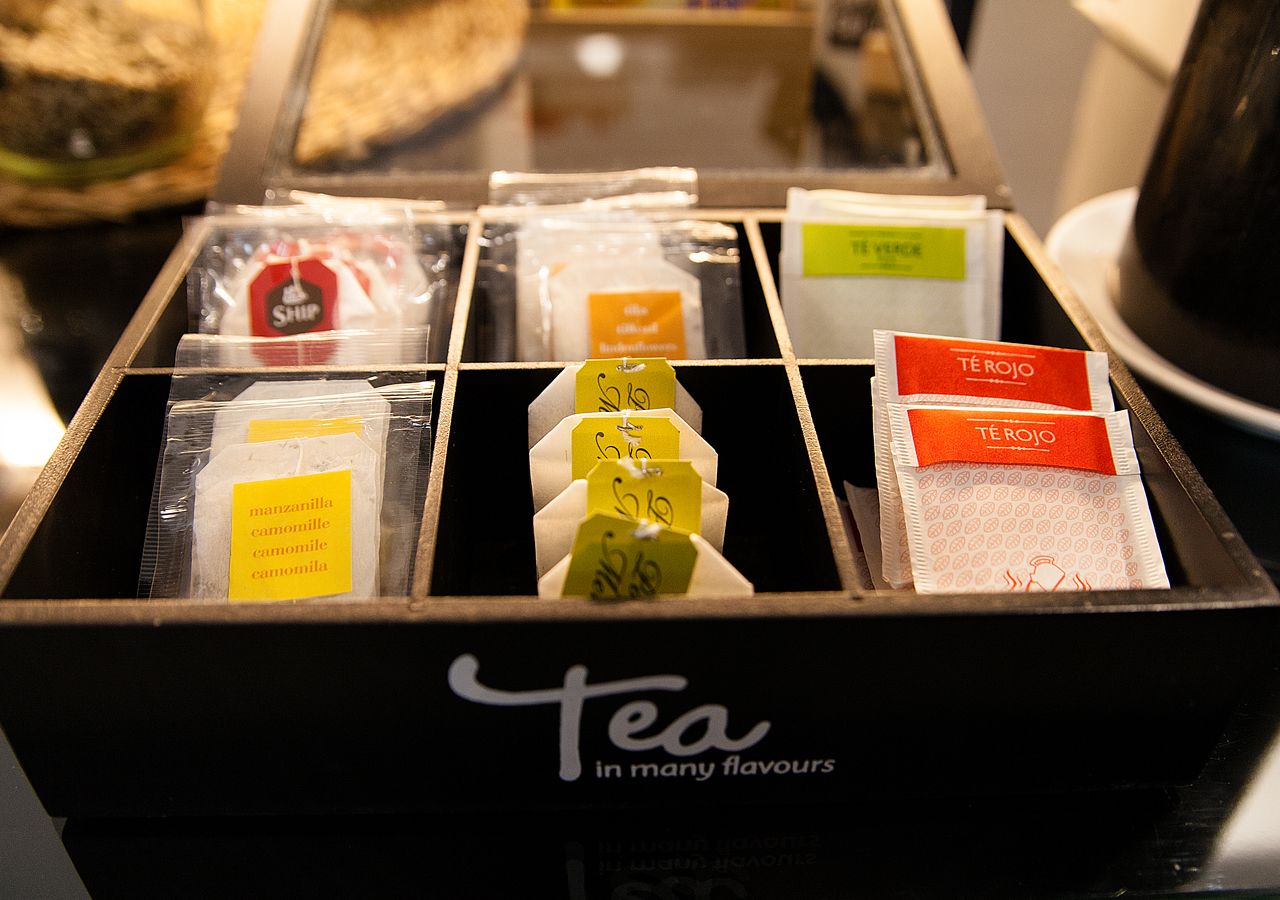 Een theedisplay met verschillende smaken, gelabeld in een doos.