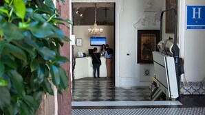 A reception area with a check-in counter, a chandelier, and a tiled floor. - Hotel Boutique Convento Cádiz (Cádiz)