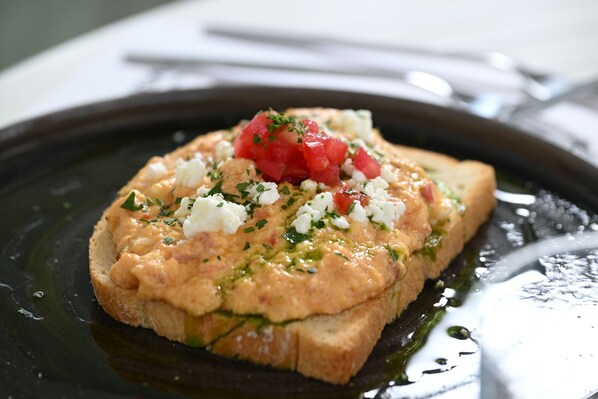Un plato con pan, tomates y queso.