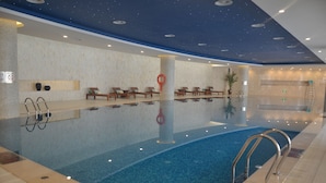 A swimming pool with lounge chairs and a ceiling with a starry design. - Sheraton Qinhuangdao Beidaihe Hotel (Qinhuangdao)