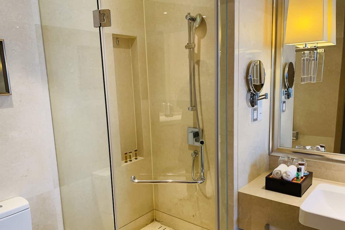 Une salle de bain moderne avec une douche à parois de verre, un lavabo et un miroir.
