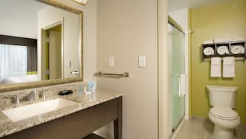 A bathroom with a sink, mirror, towel rack, and toilet.