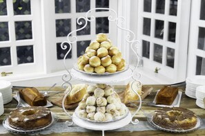 Un elegante soporte de tres niveles con diversos pasteles y tortas.