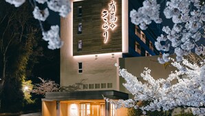 A building with illuminated signage and a modern facade. - Arima Kirari (Kobe)