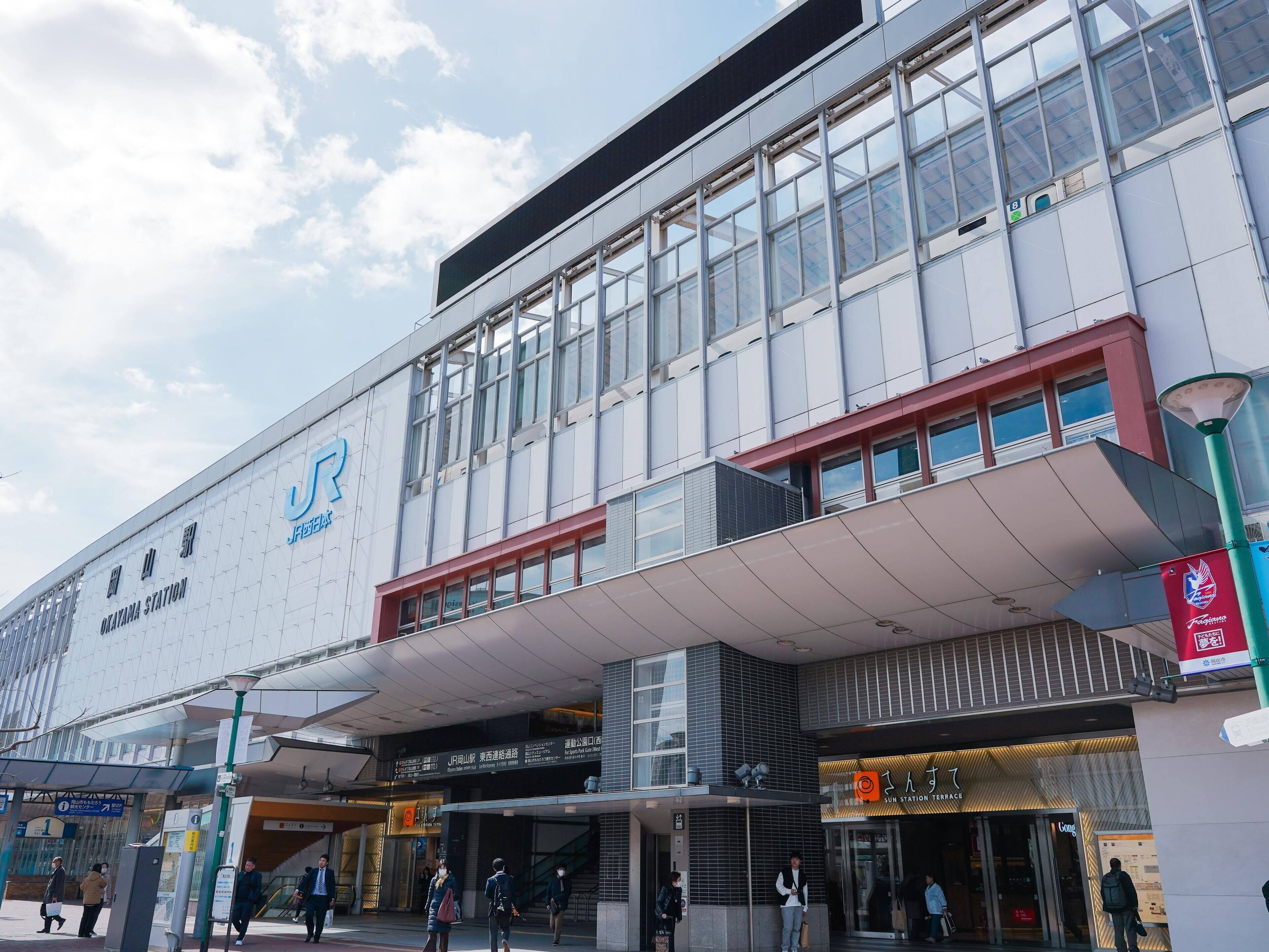 Un edificio moderno con un gran cartel de la estación Okutama.