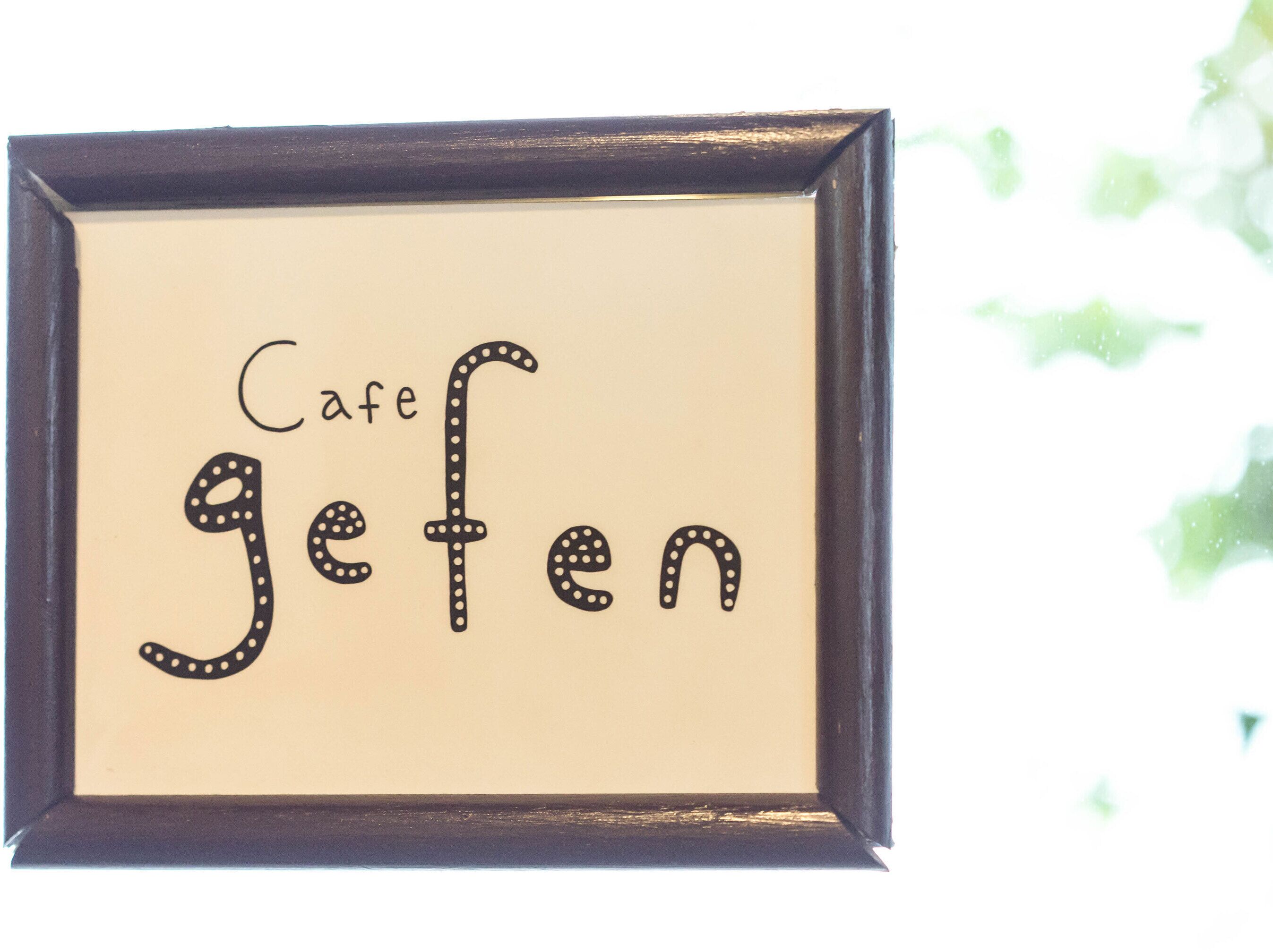 Ein gerahmtes Schild mit der Aufschrift 'Cafe gehen' in einer stilisierten Schrift.