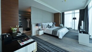 A modern hotel room with a large bed, a desk with a computer, and a seating area. - Ramee Grand Hotel & Spa (Manama)