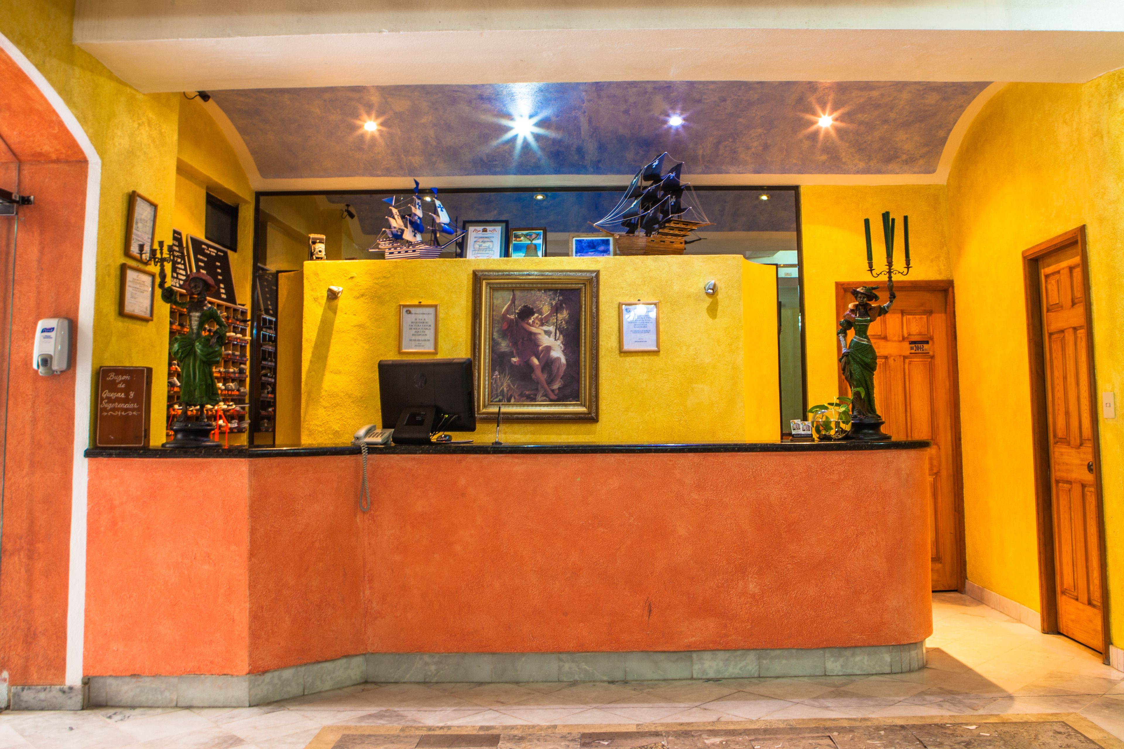 Un espace d’accueil doté d’un comptoir incurvé, de tableaux encadrés et d’une statue.