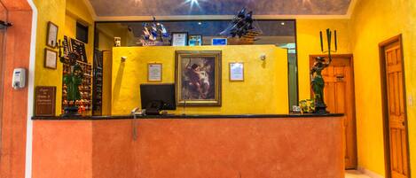 Un espace d’accueil doté d’un comptoir incurvé, de tableaux encadrés et d’une statue.