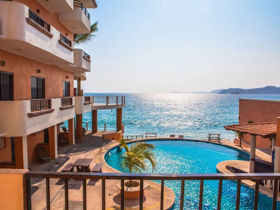 Alberca al aire libre, sombrillas en la alberca y camastros