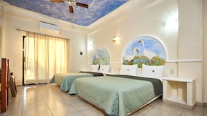 A hotel room with two beds, a ceiling fan, an air conditioning unit, and a mural of a bird on the wall.