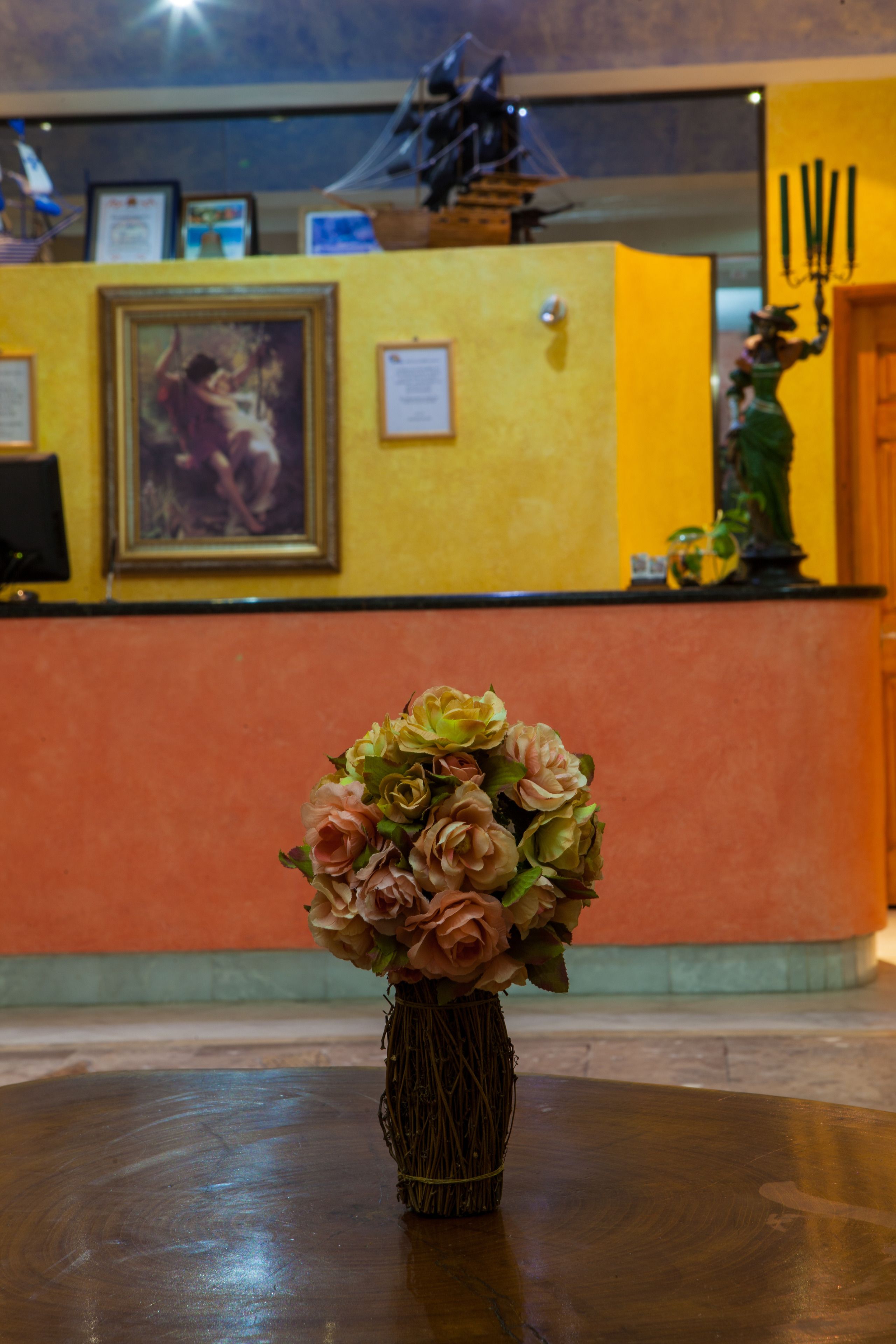A reception desk with a vase of flowers in the foreground.