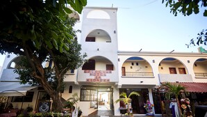 A hotel with a central courtyard, arches, and a sign reading "CASA CLUB HOTEL LA ALONDRA".