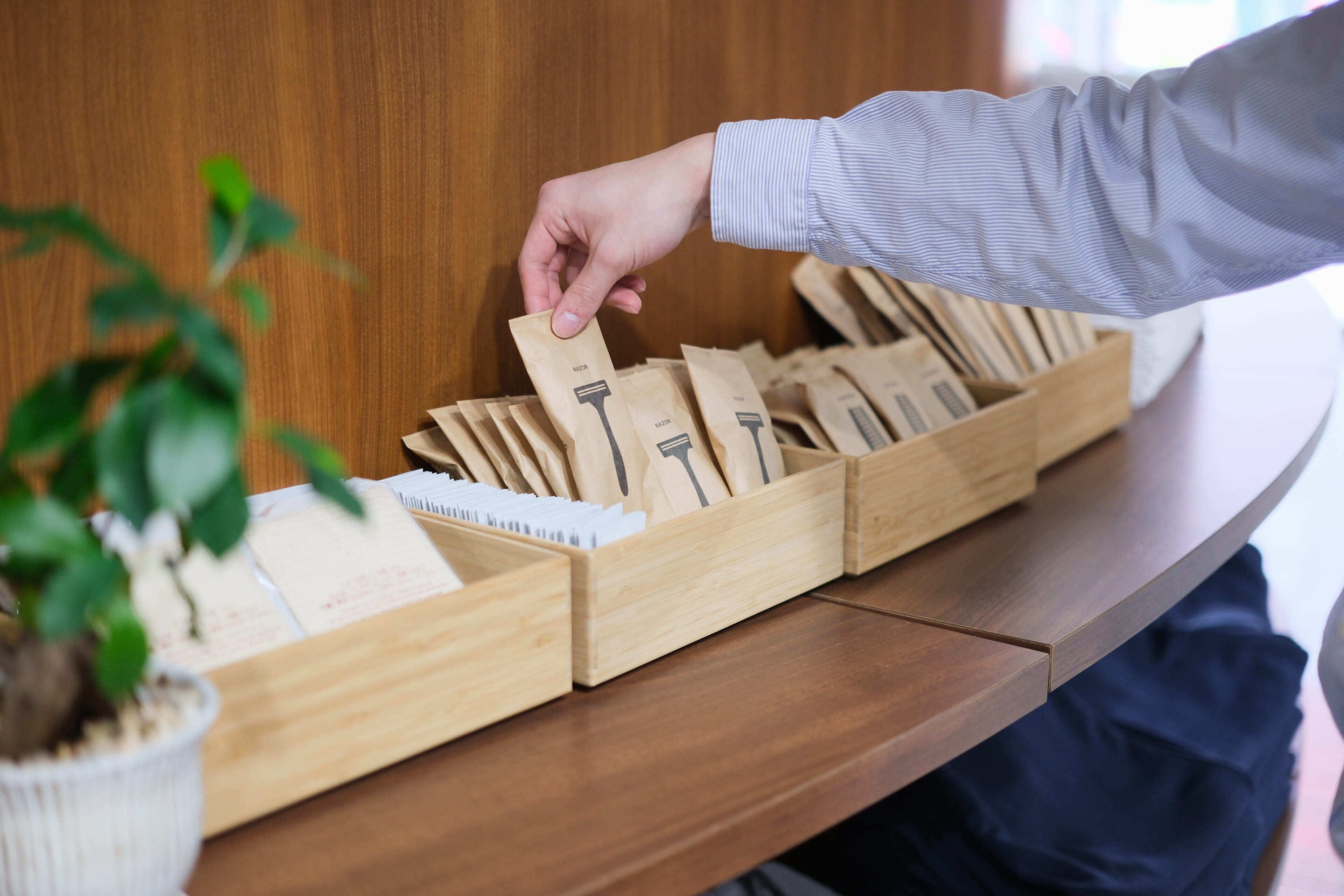 A hand selecting a card from a wooden box on a wooden table.