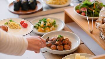 Diversos pratos em uma mesa, incluindo massa, almôndegas e saladas.
