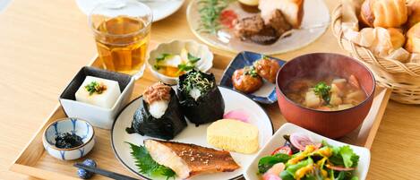 Variedad de platos japoneses, incluyendo sushi, sashimi y un tazón de sopa, servidos en una bandeja de madera.