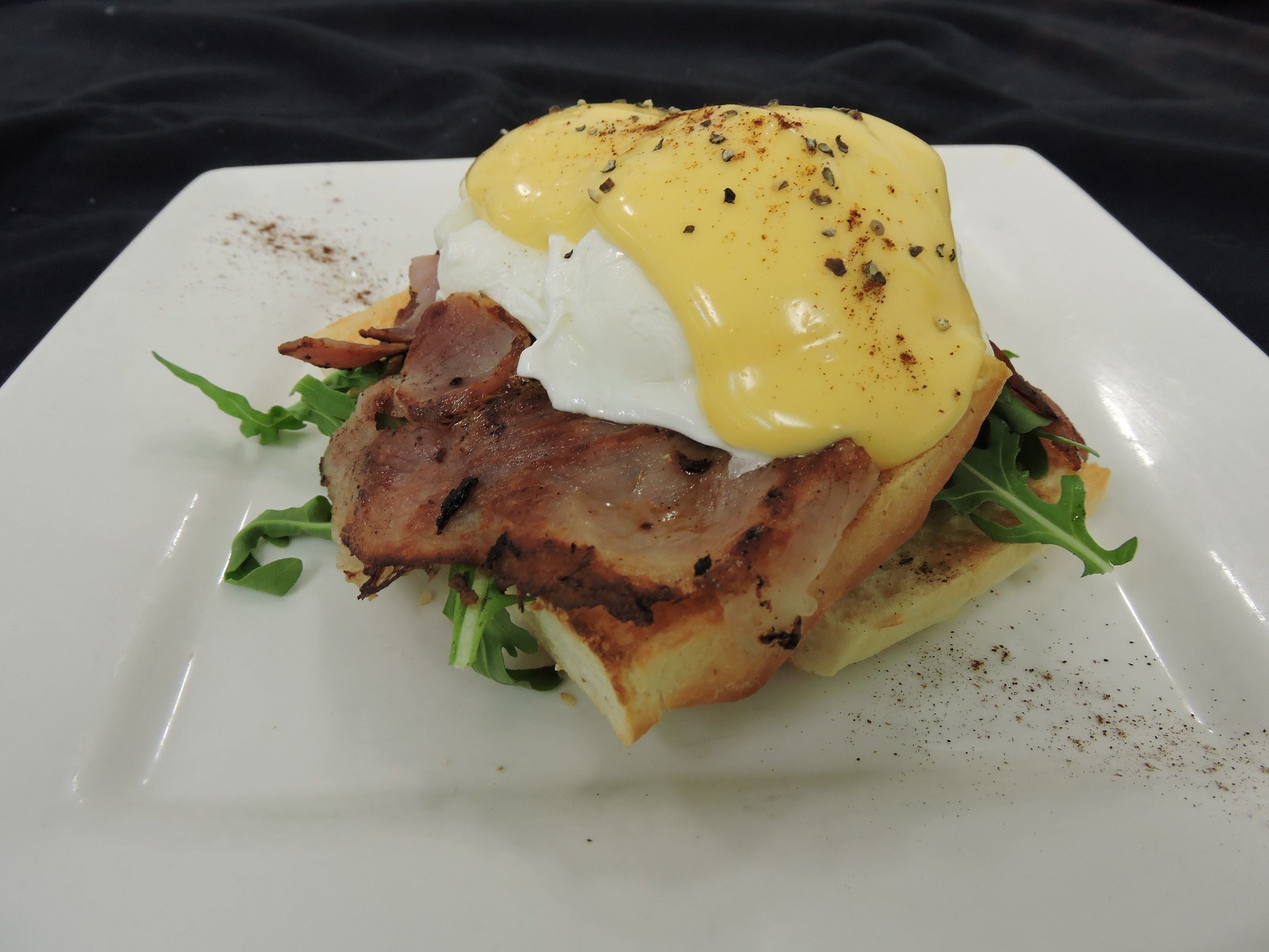 A plate with a sandwich, egg, and greens.