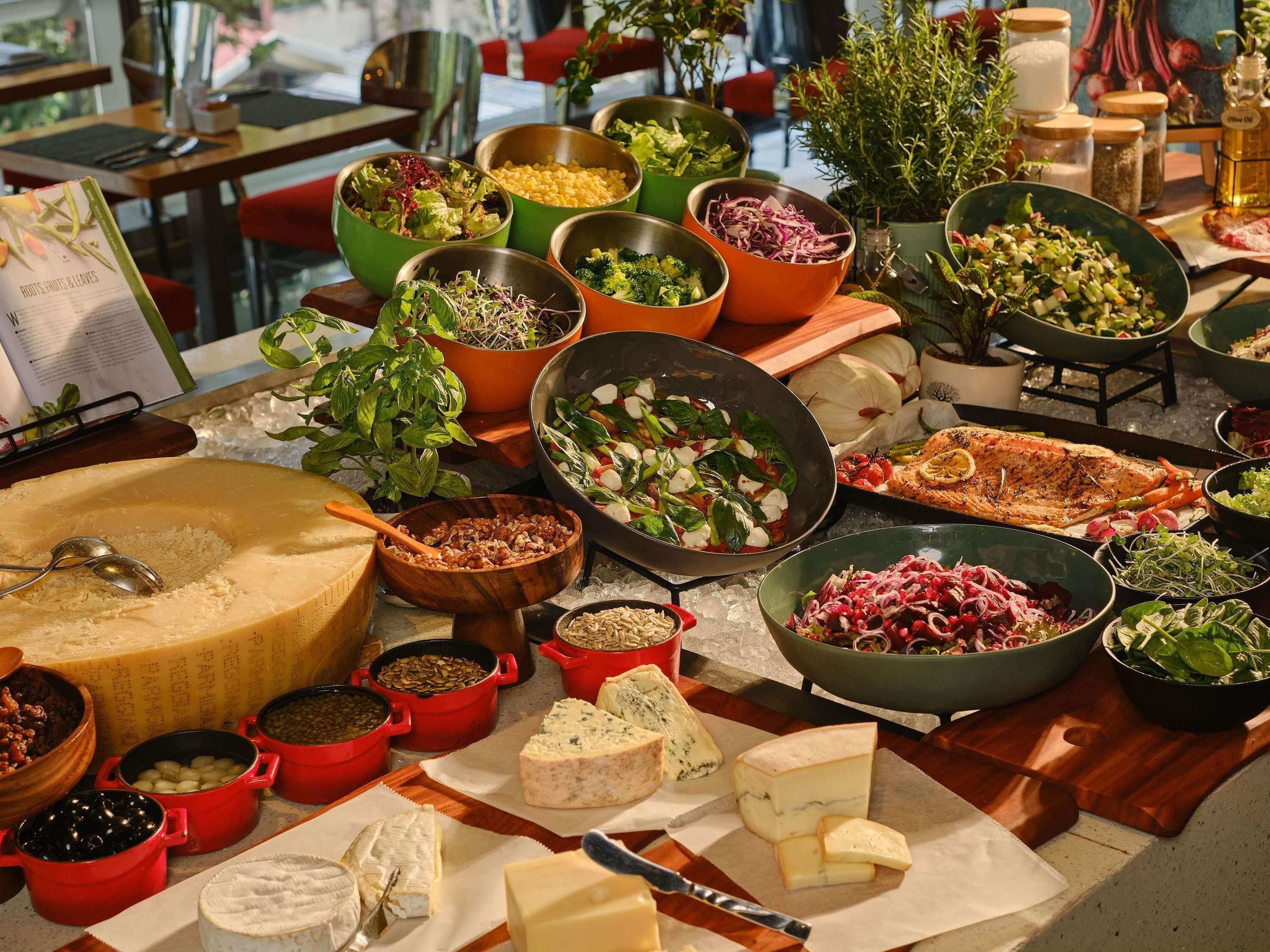 A variety of cheeses and salads on a table.