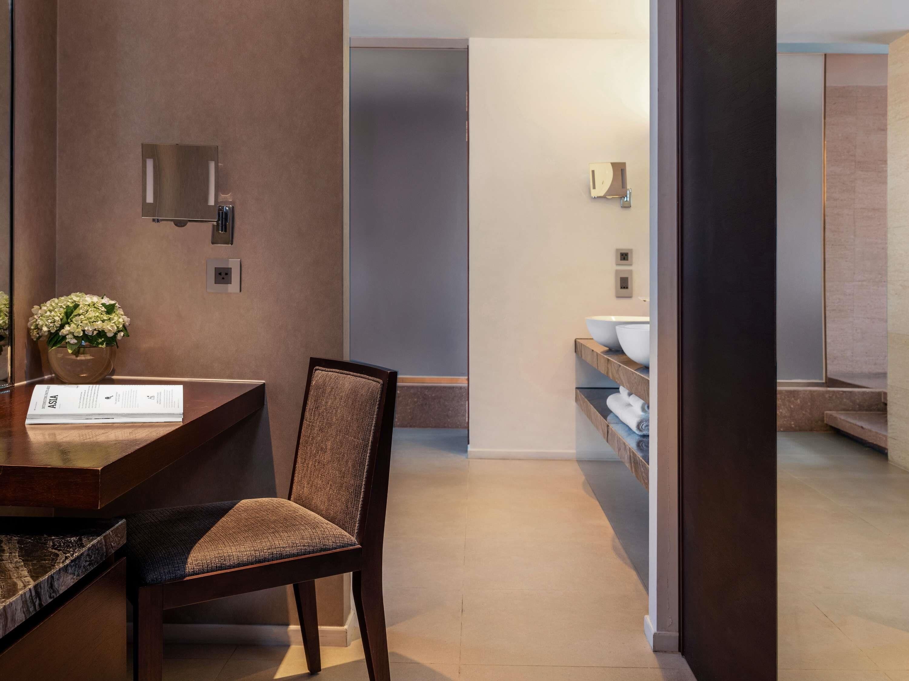 A modern bathroom with a sink, mirror, and towel rack.