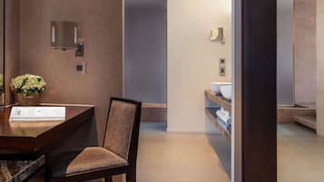 A modern bathroom with a sink, mirror, and towel rack.