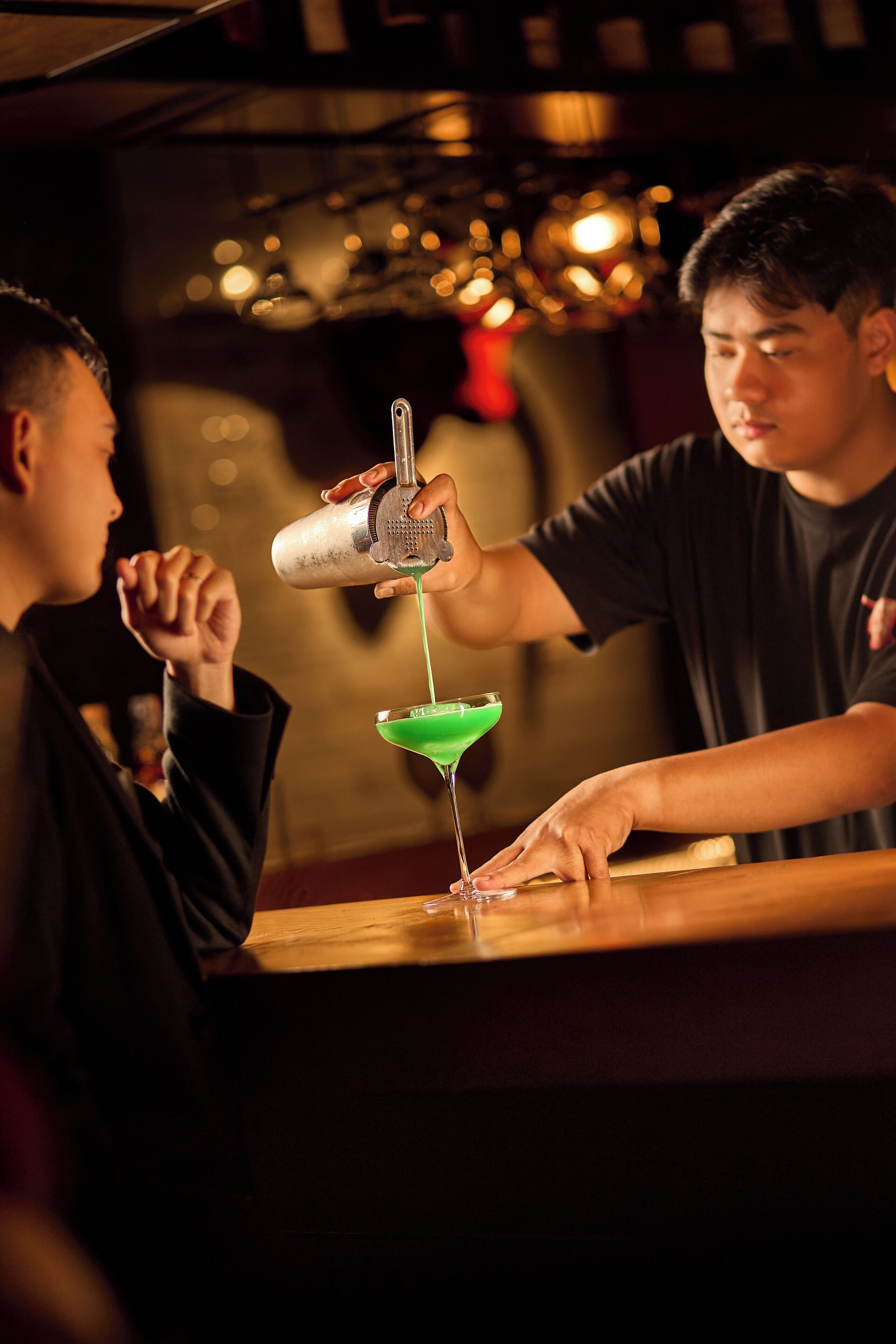 Un bar donde una persona sirve una bebida en una copa de martini.