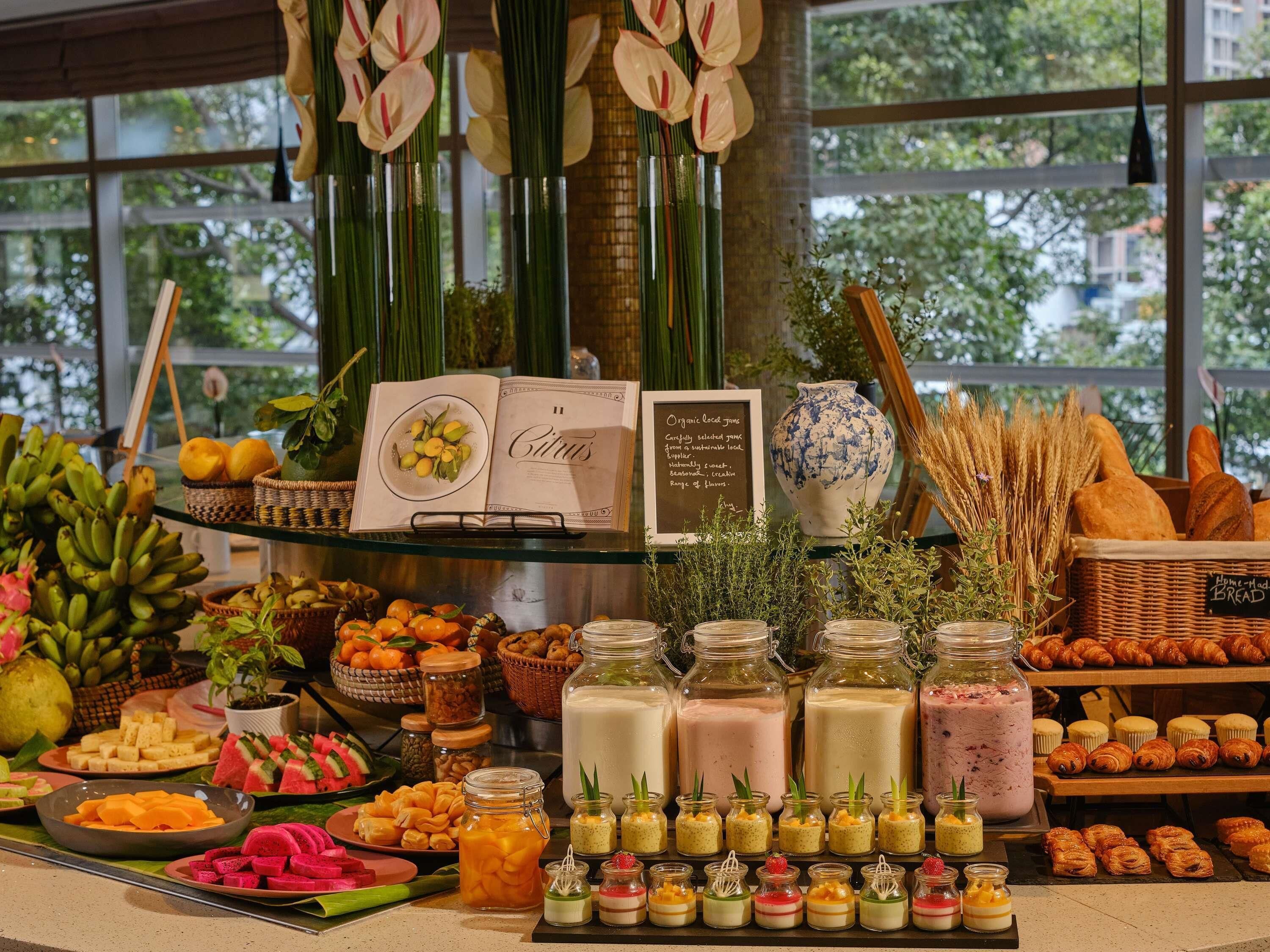 Un buffet proposant une variété de plats, notamment des fruits, des pâtisseries et des desserts.