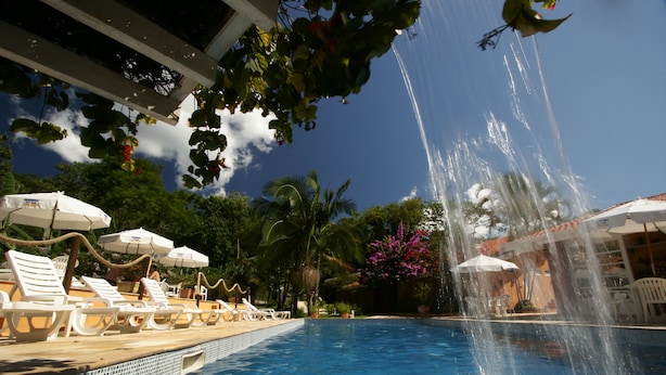 Une piscine dotée de fontaines, de chaises longues et de parasols.
