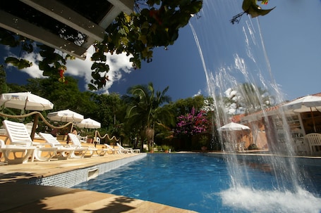 Una piscina al aire libre, sombrillas, tumbonas. Hotel Pousada Ilhasol