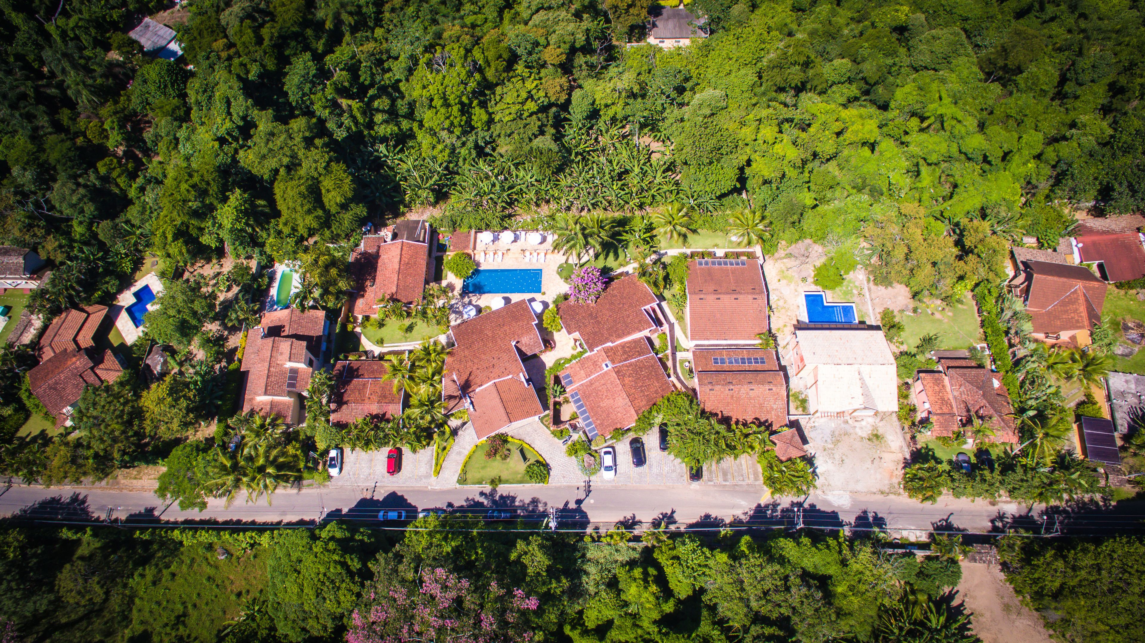 Vista aérea de una zona residencial con casas, una piscina y una carretera.