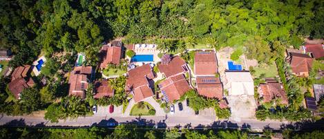 An aerial view of a residential area with houses, a swimming pool, and a road.
