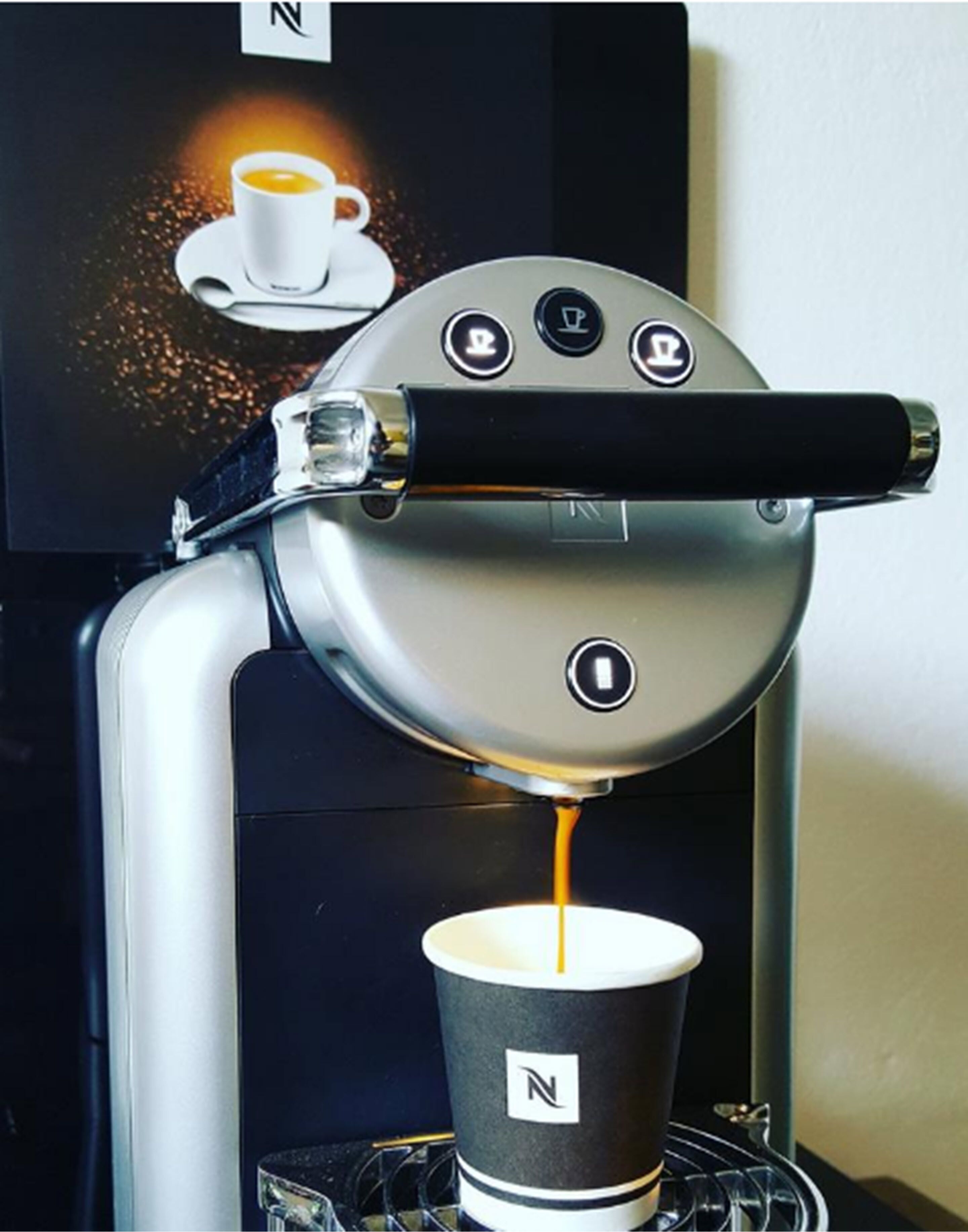 Máquina de café preparando um expresso na xícara.