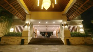 A grand entrance with a wooden ceiling, a central chandelier, and a staircase leading to an upper level. - Grand Whiz Hotel Nusa Dua (Nusa Dua)