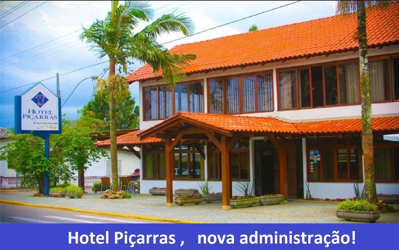 Un edificio de dos pisos con techo de tejas rojas y un letrero que indica que es el Hotel Picarras.