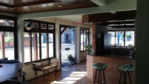 A restaurant with a bar area, seating, and a view of the street. - Hotel Piçarras (Picarras)