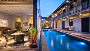 A poolside area with outdoor seating and a view of the pool. - Noordin Mews (George Town)