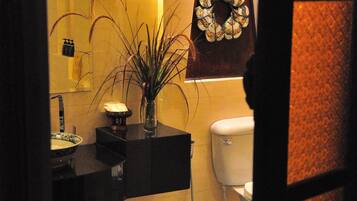A bathroom with a bathtub, toilet, sink, and a mirror.