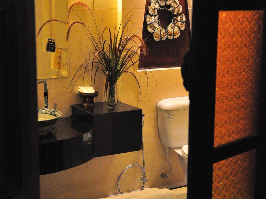 A bathroom with a bathtub, toilet, sink, and a mirror.