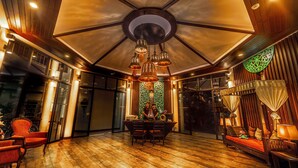 Un'ampia stanza con un grande soffitto in legno, un'area pranzo con tavolo e sedie, e un letto a baldacchino.