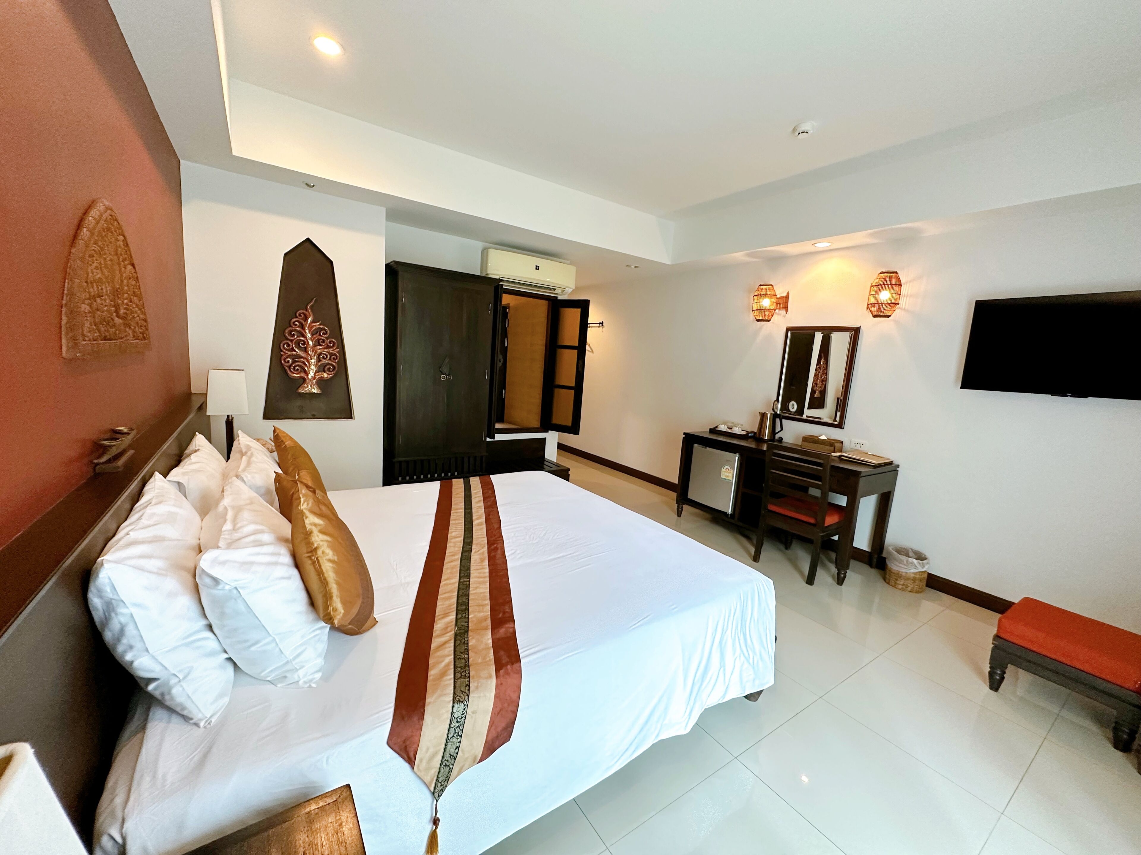 Een hotelkamer met een groot bed, een bureau, een televisie en een badkamers deur.