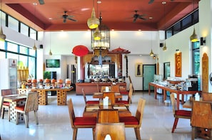 A spacious dining area with high ceilings, multiple ceiling fans, and a variety of hanging light fixtures.